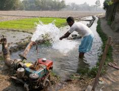 Man washing hands at motorized water pump Bangladesh 